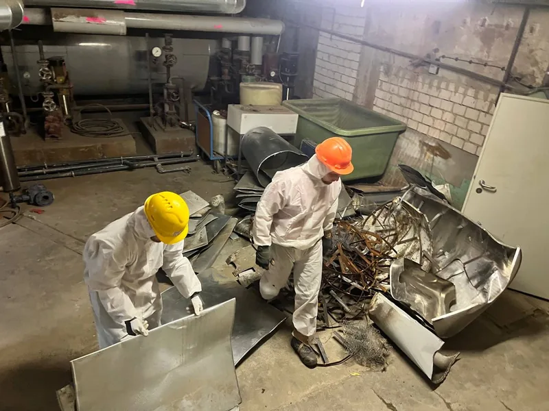 Ausbau alter Rohrdämmung in persönlicher Schutzausrüstung