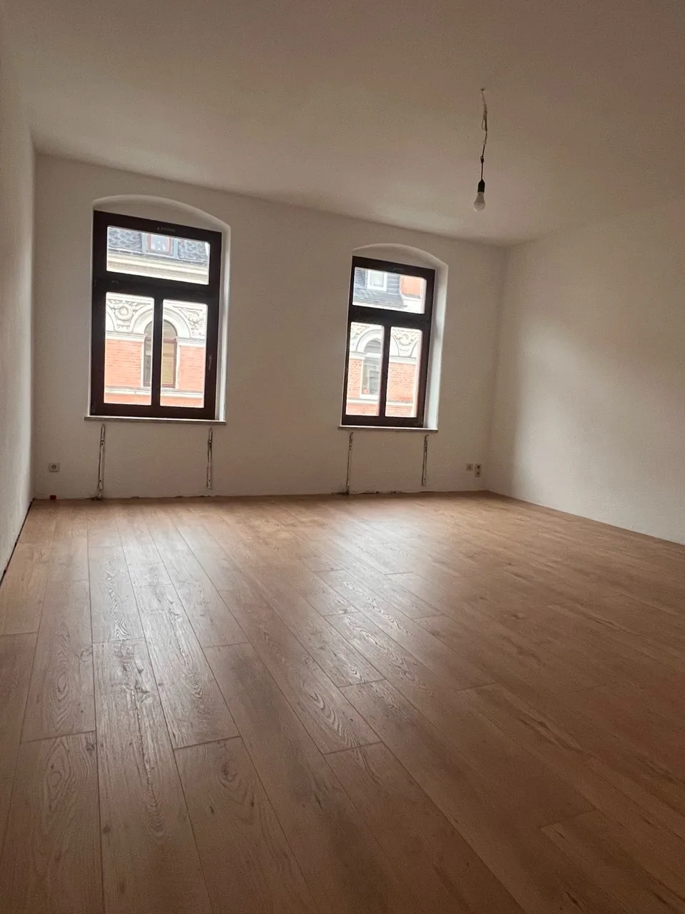 Fertiges Zimmer mit Bogenfenstern und Designboden